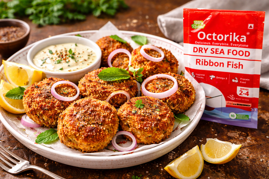 crispy golden dry fish cutlets arranged on a white ceramic plate, garnished with onion rings, fresh mint, and lemon wedges, served alongside a creamy continental dip, with an Octorika Ribbon Fish dry seafood 